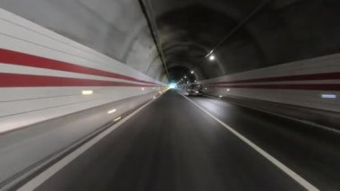 Yeraltı tünelinde ışıklarla giden araba.