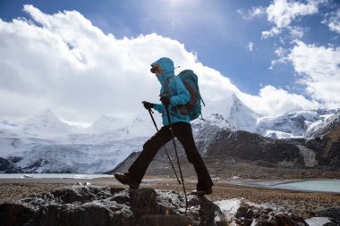 Kışın yüksek irtifada dağ yürüyüşü yapan bir kadın.