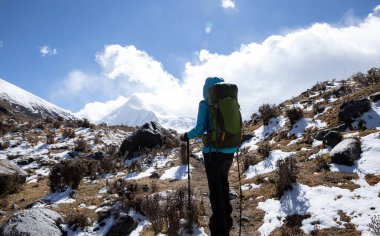 Kışın yüksek irtifada dağ yürüyüşü yapan bir kadın.