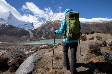 Kışın yüksek irtifada dağ yürüyüşü yapan bir kadın.