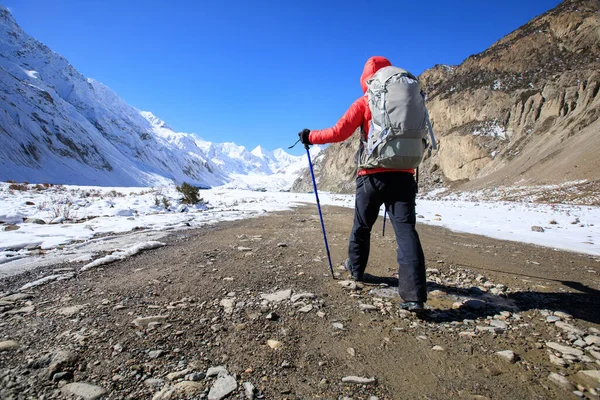 Woman backpacker hiking in winter mountains