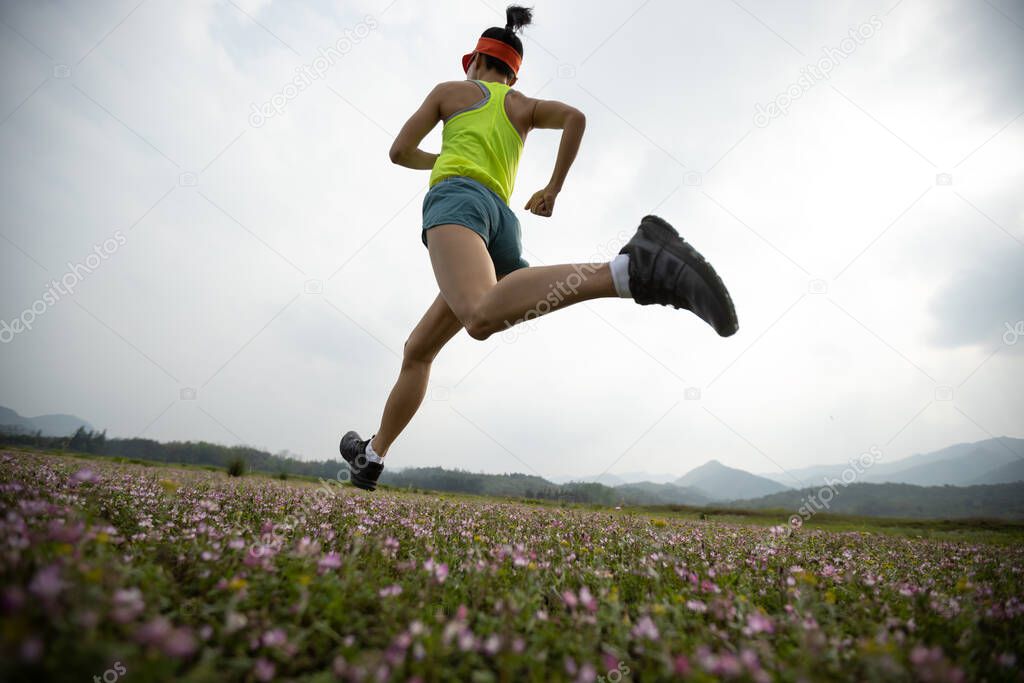 Female runner running in spring wild field