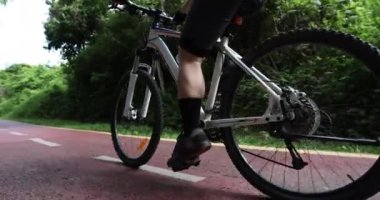 Ormanda dağ bisikleti süren kadın bisikletçi.