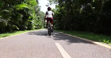 Ormanda dağ bisikleti süren kadın bisikletçi.