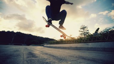 Kaykaycı kaykaycı sabahları dışarıda kaykay yapıyor.