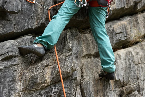 Woman rock climber climbing on the cliff