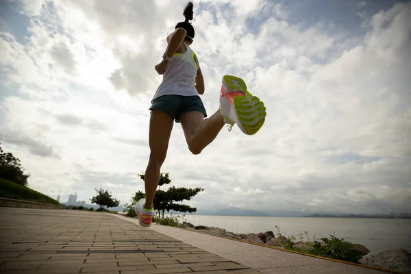 健康女人在阳光灿烂的海滨小径上参加马拉松训练 — 图库照片