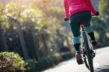 Bahar tropik parkında bisiklet süren bir kadın