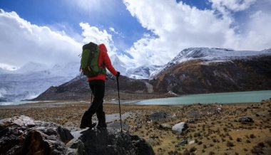 Kışın yüksek irtifada dağ yürüyüşü yapan bir kadın.