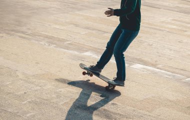 Kaykaycı bacakları açık havada kaykay yapıyor.