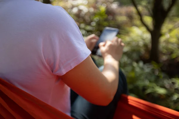 Relaks Hamaku Pomocą Smartfona Lesie Tropikalnym — Zdjęcie stockowe