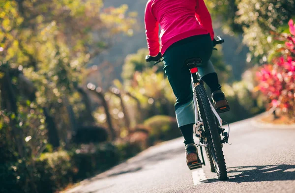 Bahar parkında tropik bisiklet süren bir kadın.