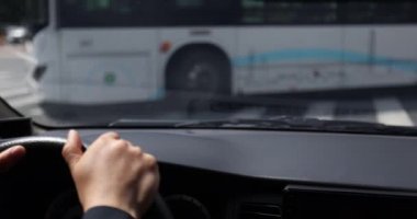 Kadın elleri direksiyonda, arabanın içinde.