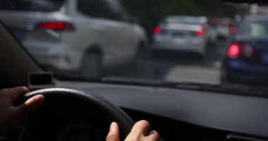 Kadın elleri direksiyonda, arabanın içinde.