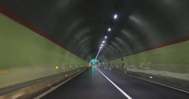 Yeraltı tünelinde ışıklarla giden araba.