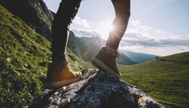 Başarılı bir kadın sırt çantalı. Gün batımı dağlarının zirvesinde yürüyüş yapıyor.