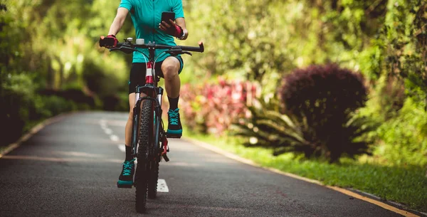 Yazın tropikal park yolunda akıllı telefon kullanan bir kadın.