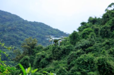 Bahar dağlarında uçan kameralı beyaz dron