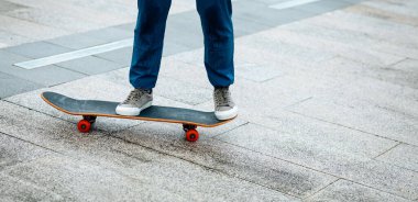 Kaykaycı şehir dışında kaykay yapıyor.