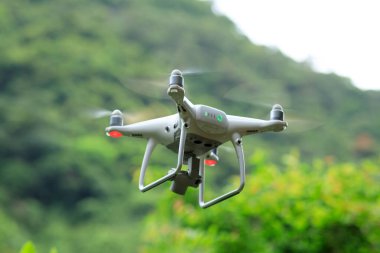 Yaz dağlarında uçan kameralı beyaz dron