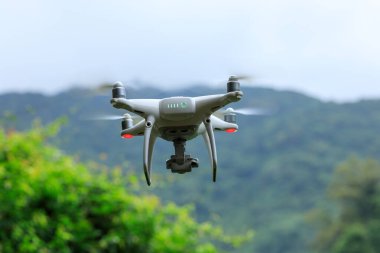 Yaz dağlarında uçan kameralı beyaz dron