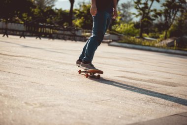 Kaykaycı kaykayla şehir dışında geziyor.