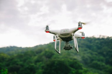 Yaz ormanlarında uçan kameralı beyaz dron
