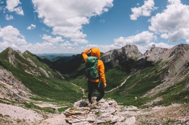 Başarılı bir kadın sırt çantalı. Gün batımı dağlarının zirvesinde yürüyüş yapıyor.