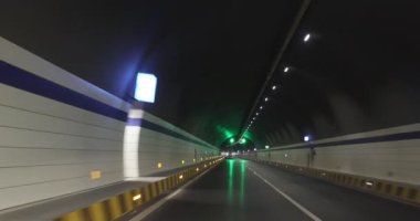 Yeraltı tünelinde ışıklarla giden araba.
