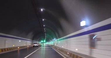 Yeraltı tünelinde ışıklarla giden araba.