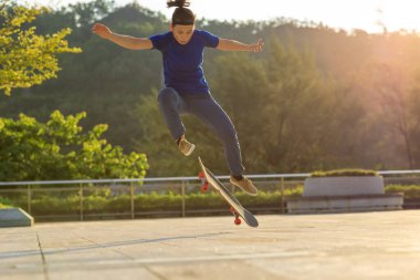 Kaykaycı şehir dışında kaykay yapıyor.