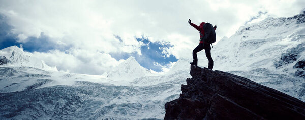 Woman hiker enjoy the view on winter mountain top cliff edge