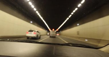 Yeraltı tünelinde ışıklarla giden araba.