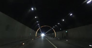 Yeraltı tünelinde ışıklarla giden araba.