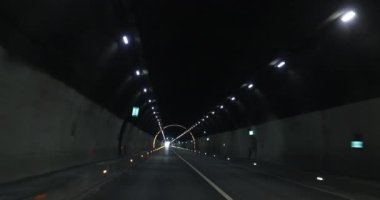 Yeraltı tünelinde ışıklarla giden araba.