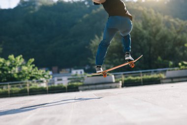 Kaykaycı şehir dışında kaykay yapıyor.