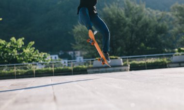 Kaykaycı şehir dışında kaykay yapıyor.