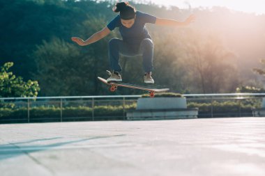 Kaykaycı şehir dışında kaykay yapıyor.