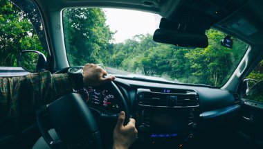 İnsanlar gün doğumunda dağ yolunda araba kullanıyorlar.