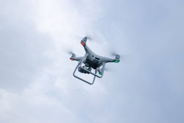 Yazın dağın tepesinde uçan kameralı beyaz dron