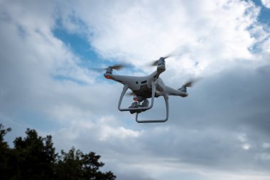 Yazın dağın tepesinde uçan kameralı beyaz dron