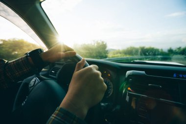 İnsanlar gün doğumunda dağ yolunda araba kullanıyorlar.