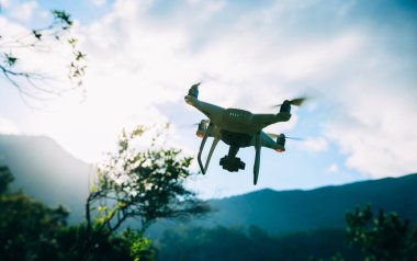 Yaz dağlarında uçan kameralı beyaz dron