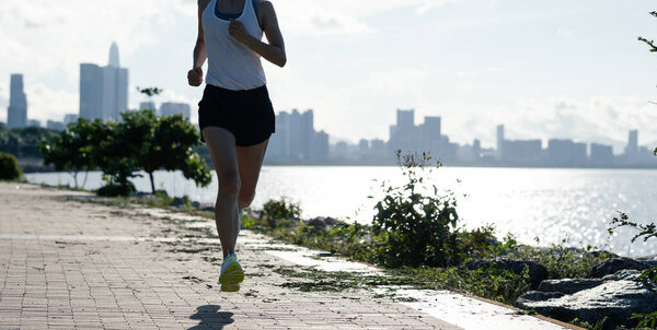 Fitness woman running on sunny tropical seaside