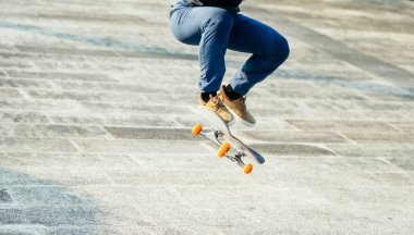 Kaykaycı şehir dışında kaykay yapıyor.