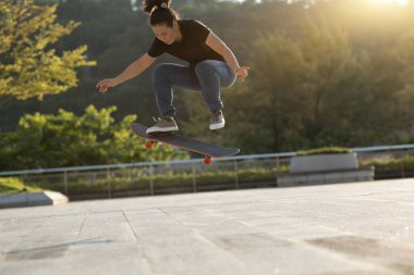 Kaykaycı şehir dışında kaykay yapıyor.