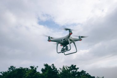 Yazın dağın tepesinde uçan kameralı beyaz dron