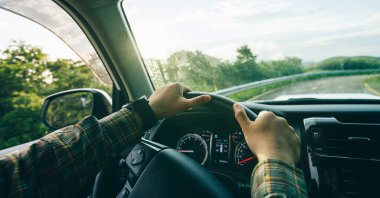 İnsanlar gün doğumunda dağ yolunda araba kullanıyorlar.