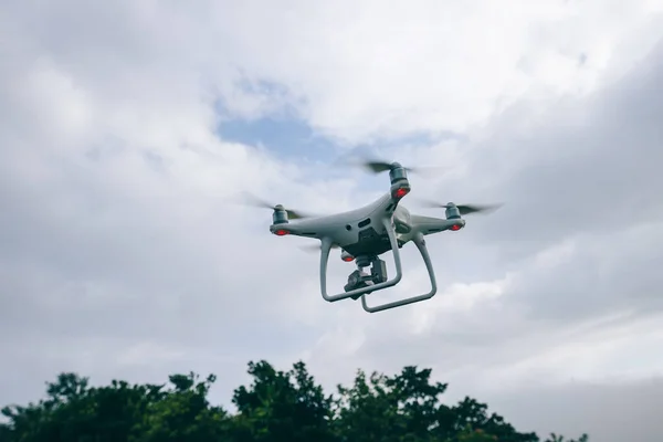 White drone with camera flying in summer mountain top