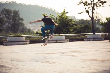 Kaykaycı şehir dışında kaykay yapıyor.